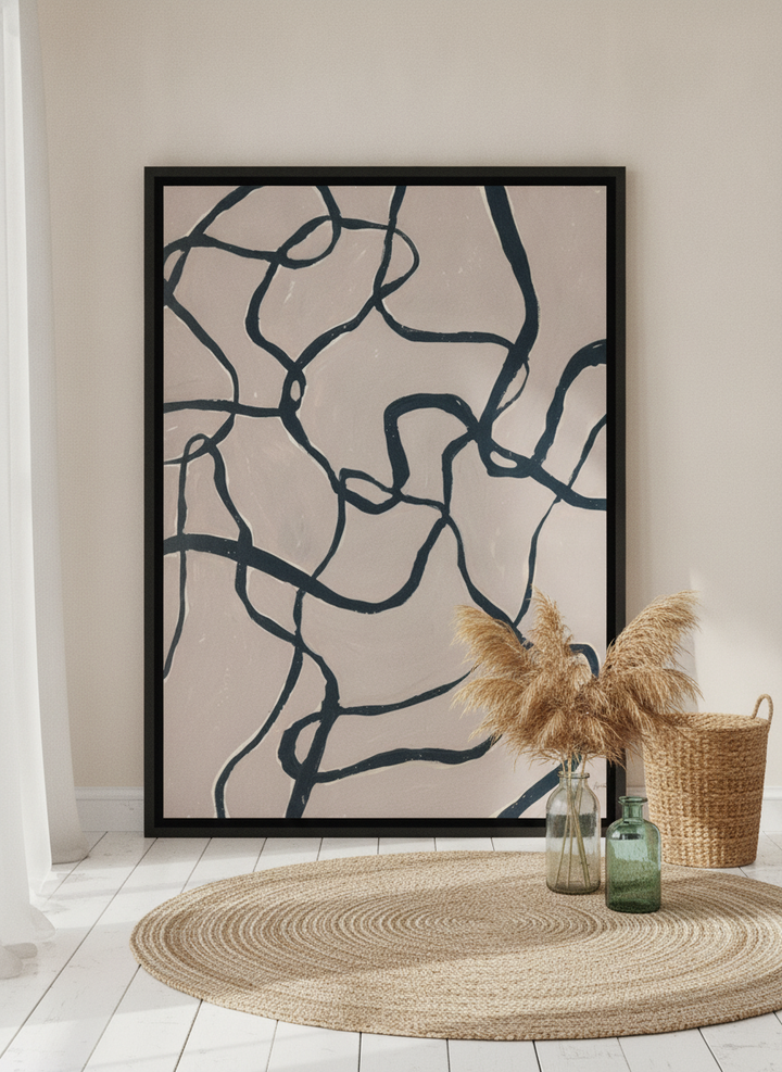 Oversized statement canvas wall art with a black surround leaning against the wall in a coastal dining room