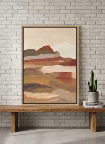 Canvas wall art with a natural timber surround standing on a bench in an industrial loft home office