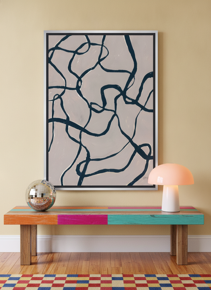 Canvas wall art with a silver leaf surround standing on a side table in a colourful eclectic home office