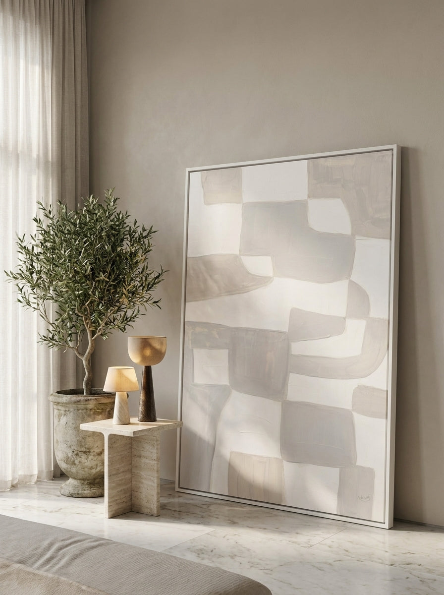 Oversized statement canvas wall art with a white surround leaning against the wall in a luxe bedroom