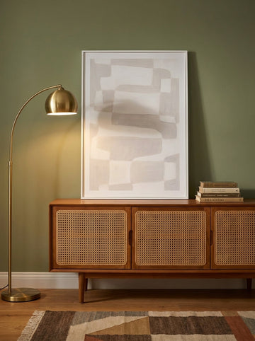 Modern wall art print standing on a sideboard in a mid-century home office