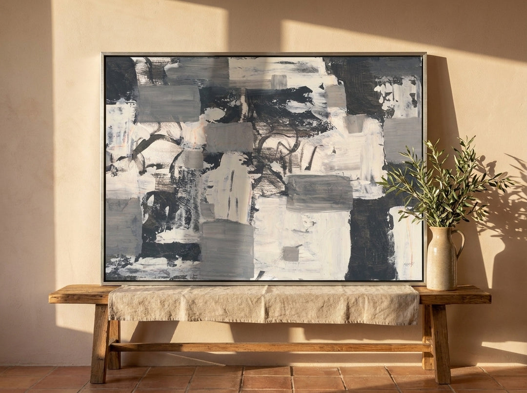 Canvas wall art with a silver leaf surround standing on a bench in a Mediterranean home office