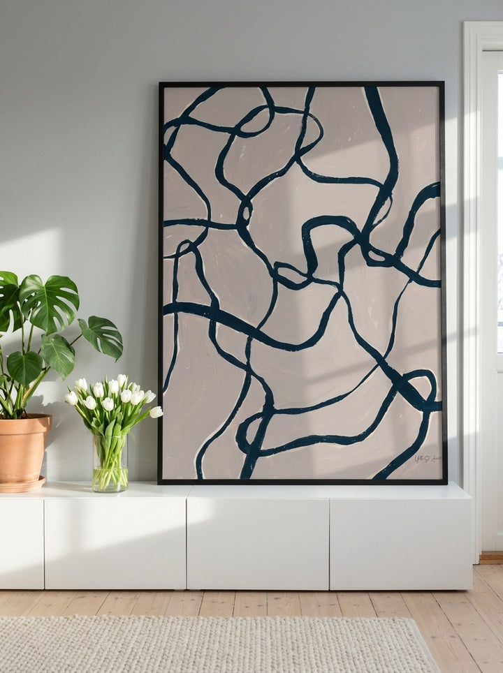 Modern wall art print standing on a sideboard in a bright Scandinavian home office