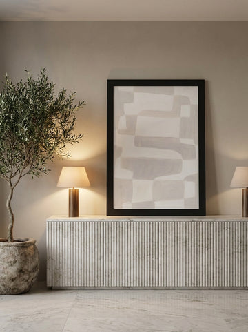 Modern wall art print standing on a sideboard in a luxe bedroom