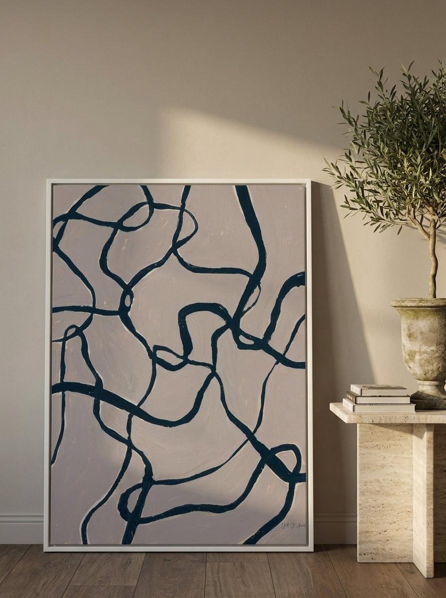 Canvas wall art with a white surround leaning against the wall in a luxe living room