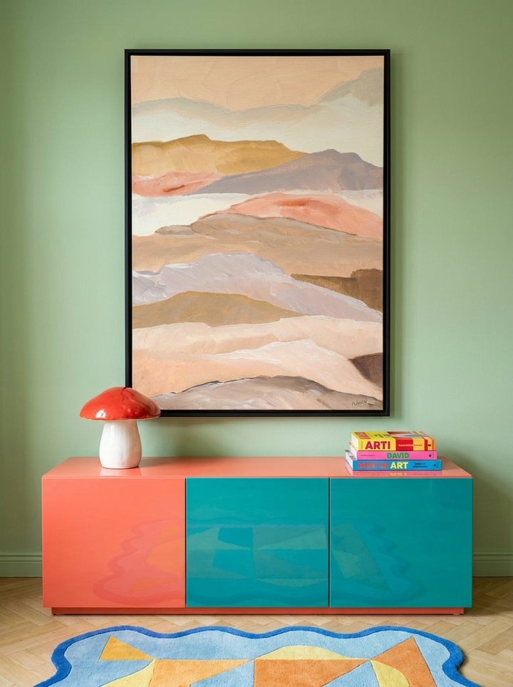 Canvas wall art with a black surround styled on the wall in a colourful eclectic living room