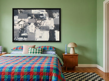 Canvas wall art with a black surround styled on the wall in a colourful eclectic bedroom
