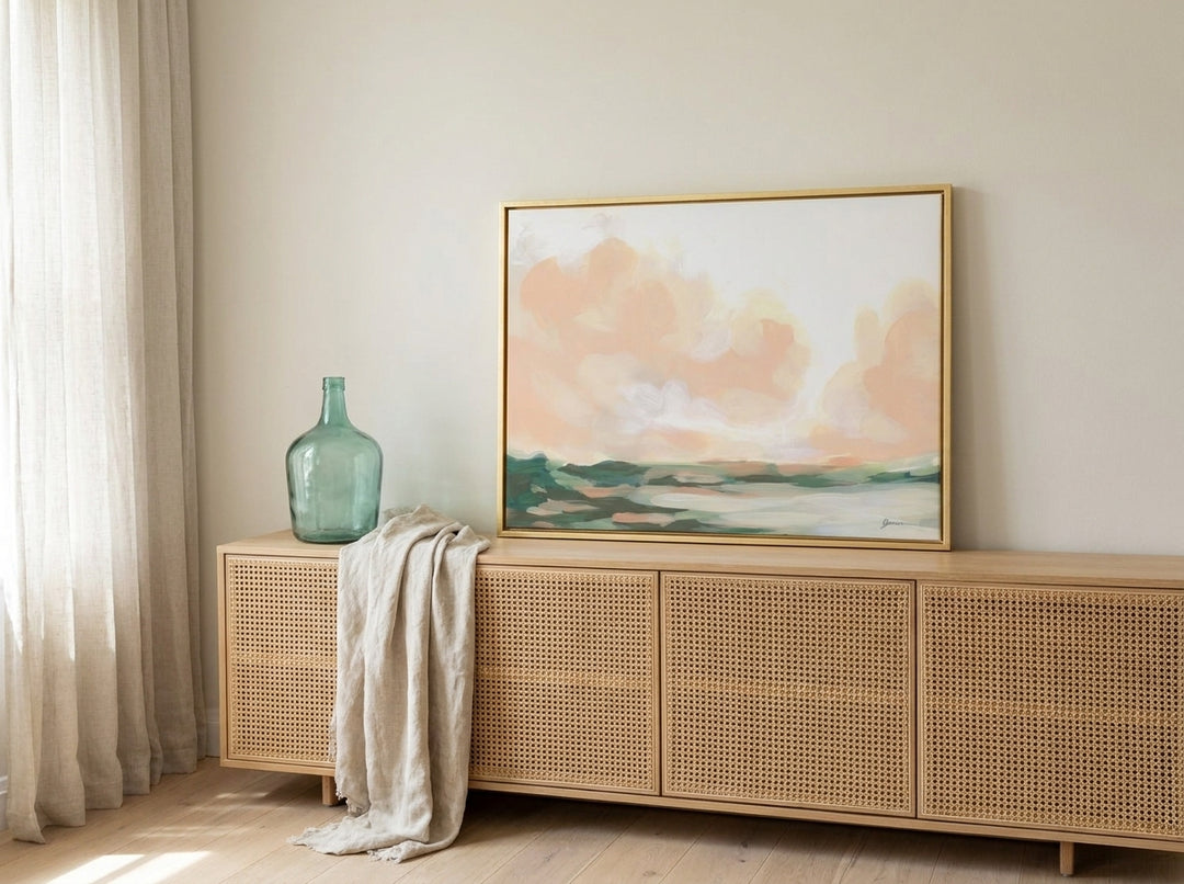 Canvas wall art with a gold leaf surround standing on a sideboard in a coastal bathroom