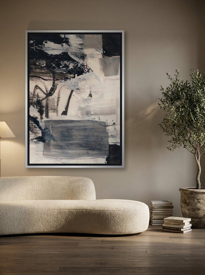 Oversized statement canvas wall art with a silver leaf surround styled on the wall in a luxe living room