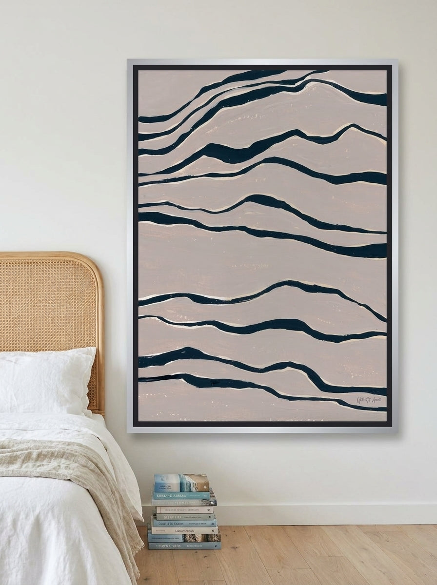 Canvas wall art with a silver leaf surround styled on the wall in a coastal bedroom