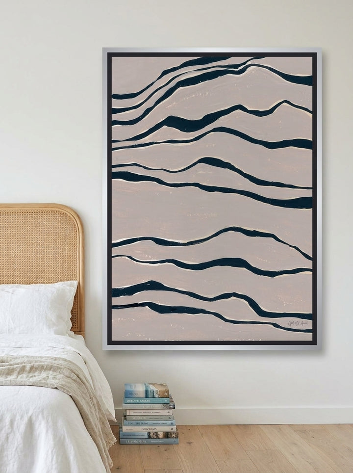 Canvas wall art with a silver leaf surround styled on the wall in a coastal bedroom