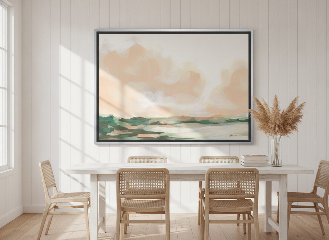 Oversized statement canvas wall art with a silver leaf surround styled on the wall in a coastal dining room