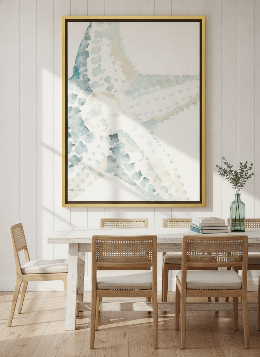 Oversized statement canvas wall art with a gold leaf surround styled on the wall in a coastal dining room