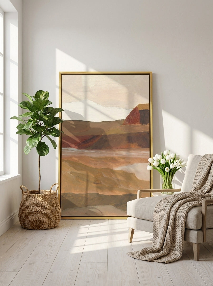Oversized statement canvas wall art with a gold leaf surround leaning against the wall in a bright Scandinavian living room