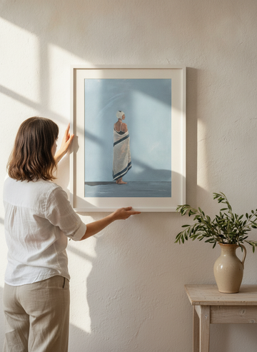 Person holding modern wall art print in a Mediterranean living room