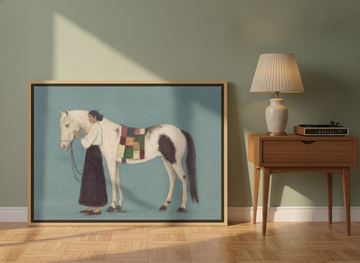 Canvas wall art with a natural timber surround leaning against the wall in a mid-century bedroom