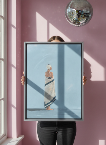Person holding canvas wall art with a silver leaf surround in a colourful eclectic living room