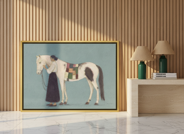 Canvas wall art with a gold leaf surround leaning against the wall in a luxe dining room