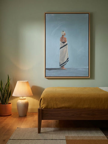 Canvas wall art with a natural timber surround styled on the wall in a mid-century bedroom