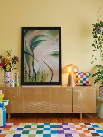 Modern wall art print standing on a sideboard in a colourful eclectic living room