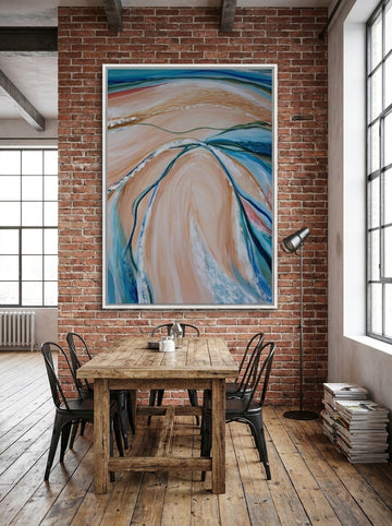 Oversized statement canvas wall art with a white surround styled on the wall in an industrial loft dining room