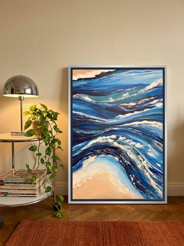 Canvas wall art with a silver leaf surround leaning against the wall in a retro 70s living room