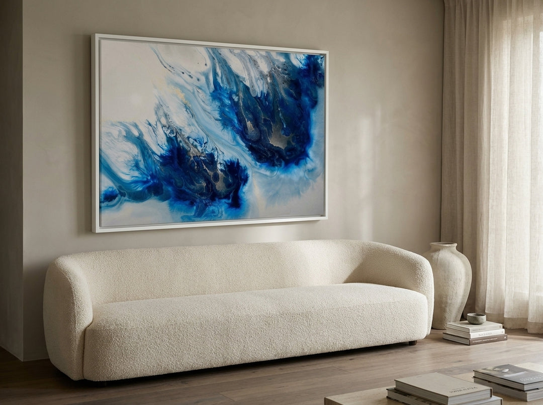 Oversized statement canvas wall art with a white surround styled on the wall in a luxe living room