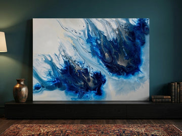 Stretched canvas wall art standing on a console in a moody living room