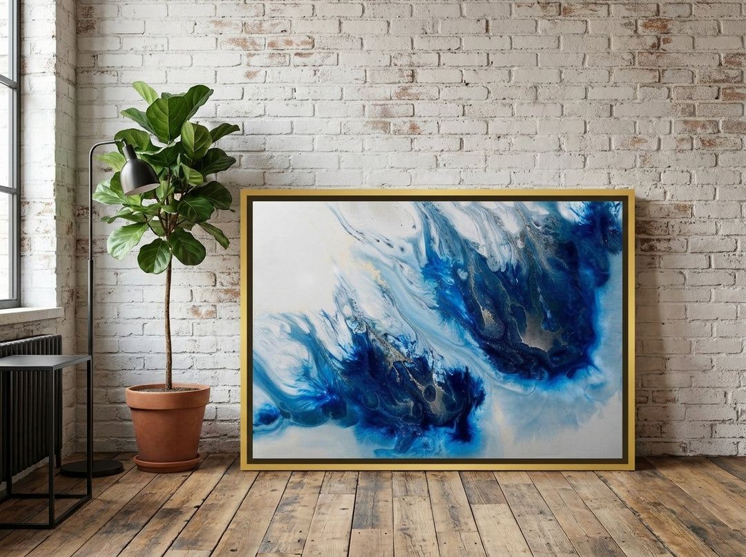 Canvas wall art with a gold leaf surround leaning against the wall in an industrial loft dining room