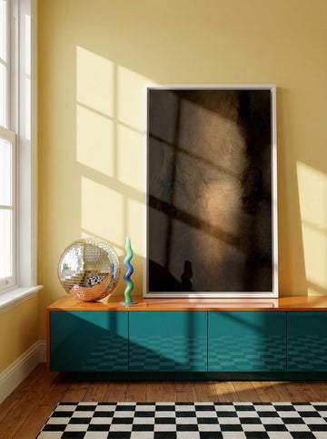 Canvas wall art with a white surround standing on a sideboard in a colourful eclectic bedroom