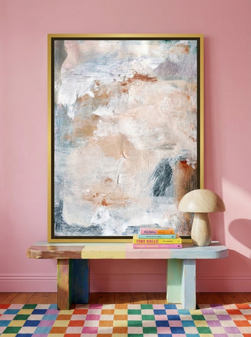 Canvas wall art with a gold leaf surround standing on a side table in a colourful eclectic home office