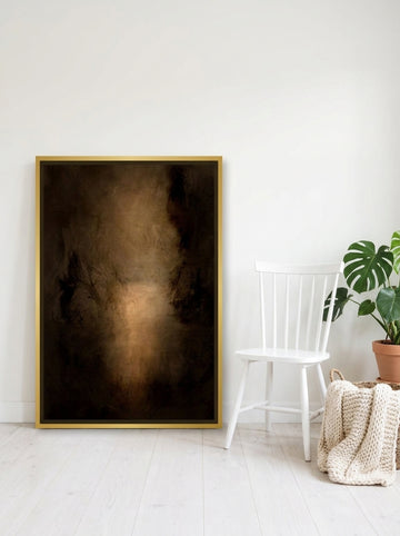 Canvas wall art with a gold leaf surround leaning against the wall in a bright Scandinavian home office