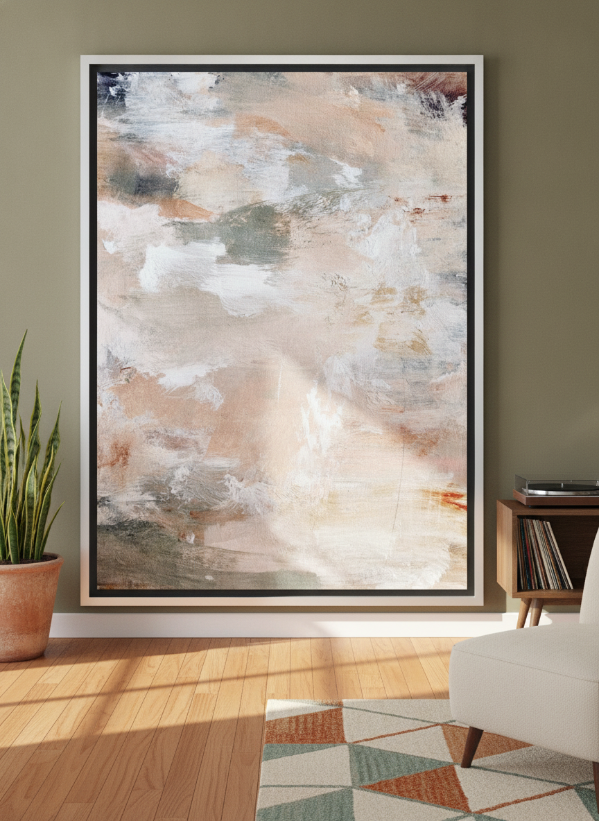 Oversized statement canvas wall art with a silver leaf surround leaning against the wall in a mid-century living room