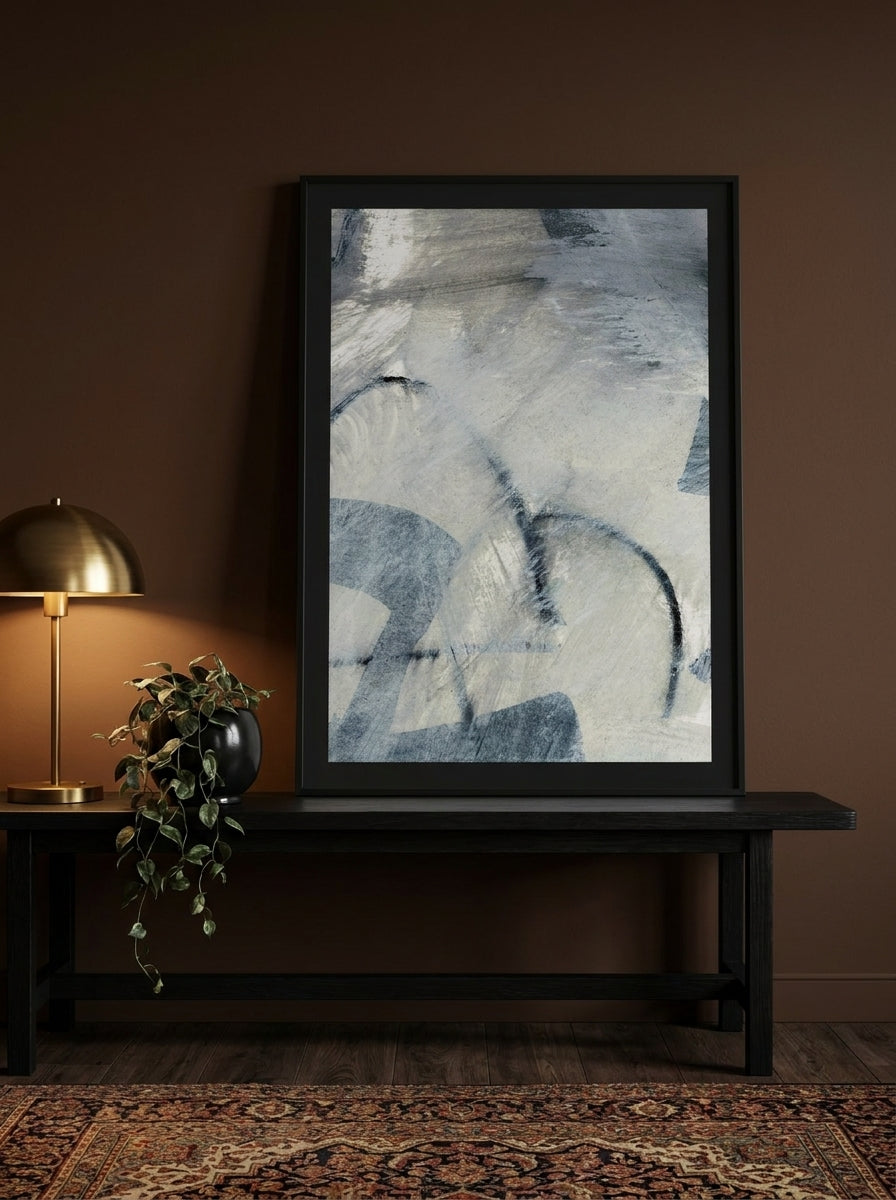 Modern wall art print standing on a console in a moody living room