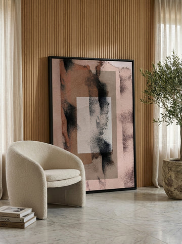 Oversized statement canvas wall art with a black surround leaning against the wall in a luxe living room