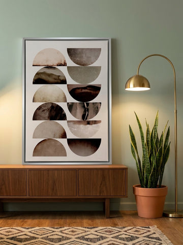 Canvas wall art with a silver leaf surround standing on a sideboard in a mid-century home office