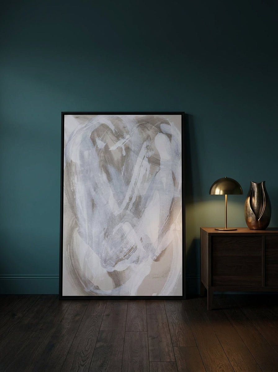 Oversized statement canvas wall art with a black surround leaning against the wall in a moody living room