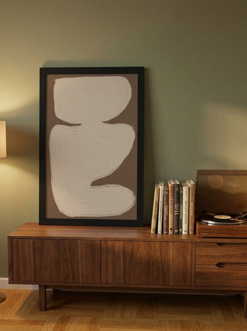 Modern wall art print standing on a sideboard in a mid-century living room