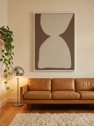 Oversized statement canvas wall art with a white surround styled on the wall in a retro 70s living room