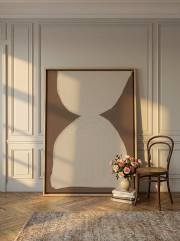 Oversized statement canvas wall art with a natural timber surround leaning against the wall in a Parisian bedroom