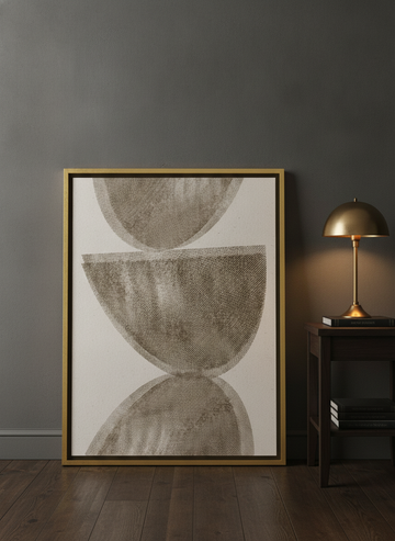 Canvas wall art with a gold leaf surround leaning against the wall in a moody home office