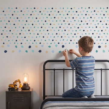 Pastel Pebble Dots Wall Sticker Decals wall decals: a boy putting the decals up in a boy's bedroom
