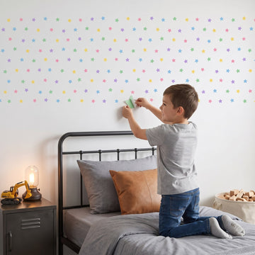 Pastel Star Shower Wall Sticker Decals wall decals: a boy putting the decals up in a boy's bedroom