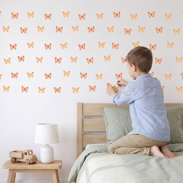 Sunset Glow Butterflies Wall Sticker Decals wall decals: a boy putting the decals up in a boy's bedroom