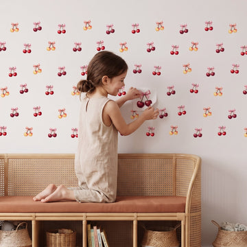 Cherries with Pink Bow Wall Sticker Decals wall decals: a girl putting the decals up in a playroom