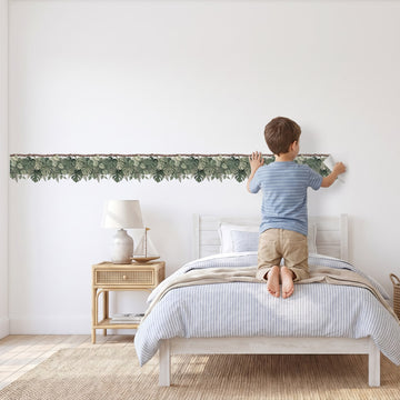 Monstera Vine Trim Wall Sticker Decals wall decals: a boy putting the decals up in a boy's bedroom