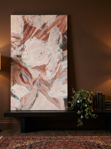 Stretched canvas wall art standing on a console in a moody living room