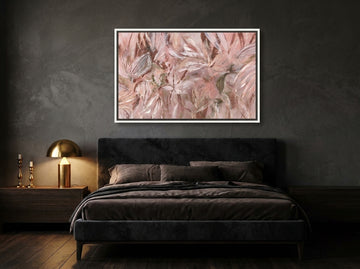 Canvas wall art with a white surround styled on the wall in a moody bedroom