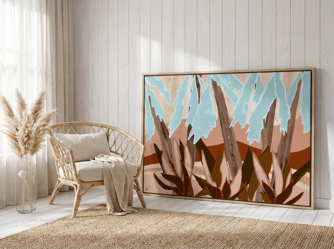 Oversized statement canvas wall art with a natural timber surround leaning against the wall in a coastal dining room