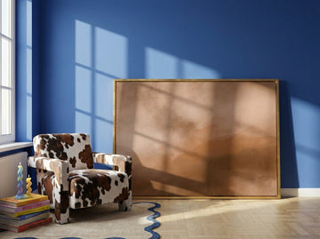 Canvas wall art with a gold leaf surround leaning against the wall in a colourful eclectic home office